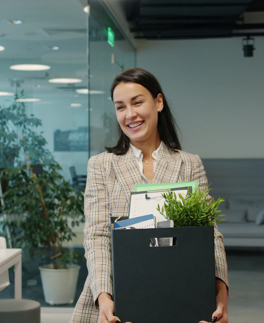 Femme quittant son bureau avec un carton